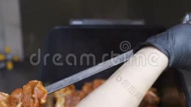 一个人正把肉串在扦子上。 美味可口的开胃小菜串在烤肉串上